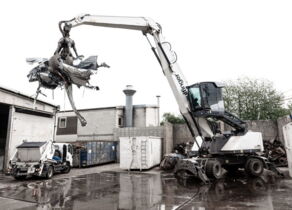 Weißer Bagger lädt Schrott auf Wertstoffhof in Möglingen