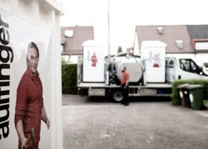 Toilettenkabine mit Absaugfahrzeug im Hintergrund