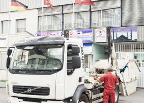 LKW setzt Mulde ab vor türkischer und deutscher Flagge